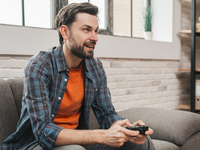 Source: Magnific; Copyright: freepik; URL: https://www.magnific.com/free-photo/smiling-portrait-young-man-sitting-sofa-playing-video-game_4503149.htm; License: Licensed by JMIR.