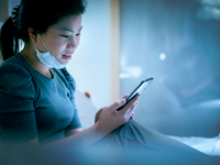 Source: Freepik; Copyright: Lifestylememory; URL: https://www.freepik.com/free-photo/smartphone-addictionasian-female-using-smartphine-bed-late-night-while-still-wearing-face-mask-virus-protective-female-enjoy-using-smartphone-application-bedroom_25192282.htm; License: Licensed by JMIR.