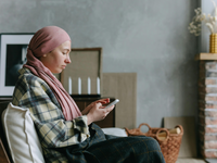 Patient using a smartphone to report symptoms at home, representing digital symptom monitoring in acute oncology care. Source: Pexels; Copyright: Thirdman; URL: https://www.pexels.com/photo/healthy-woman-relaxation-smartphone-7659358/; License: Licensed by JMIR.